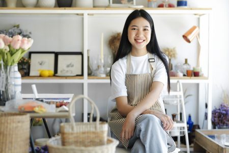 Portrait of a young asian confident woman arms crossed smiling at camera.