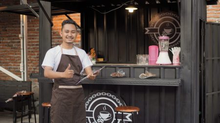 asian man in bar apron carrying a sign menu list ok in a container theme angkringan