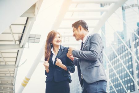 Business couple hands up doing yes outdoor. Concept of teamwork