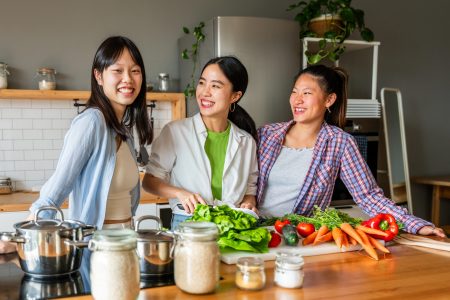 Happy beautiful chinese women friends bonding at home and cooking delicious meal together- Playful pretty asian female adults meeting and having fun at home, concepts about lifestyle, domestic life and friendship